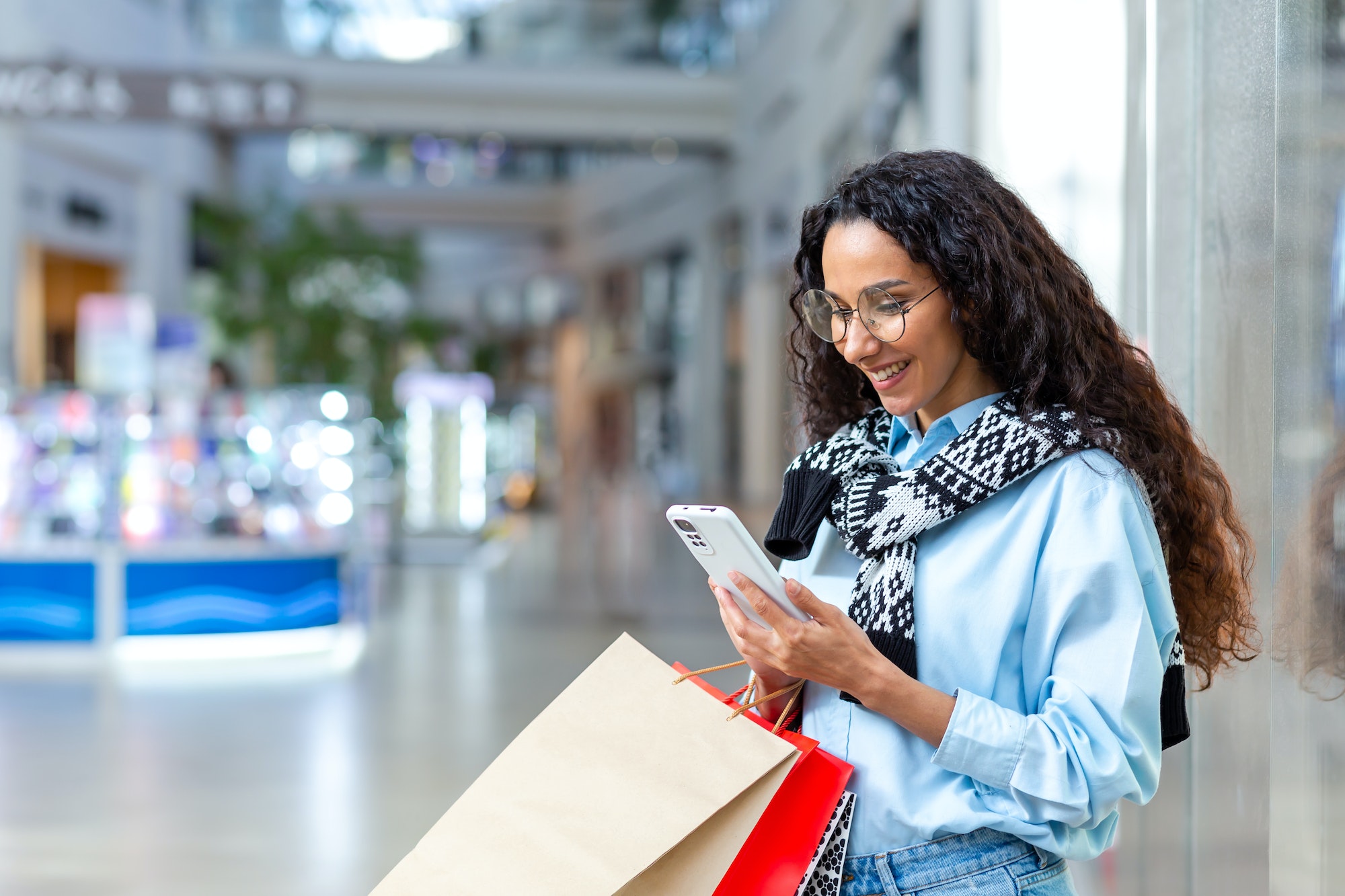 Happy woman shopping for clothes during the period of discounts and promotional offers, Hispanic