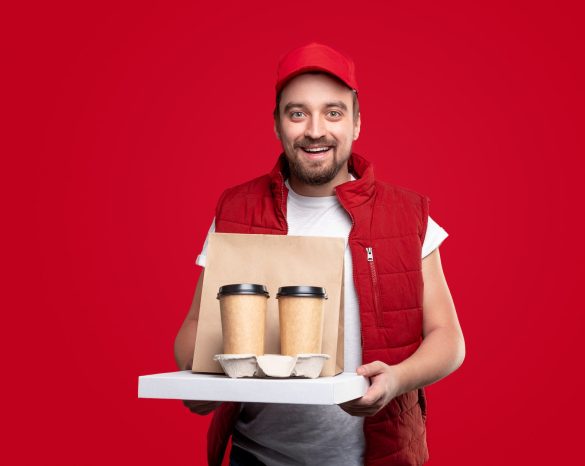 Cheerful delivery man with food and drinks